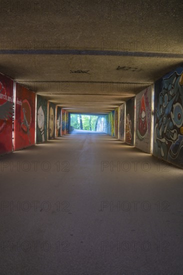 View through an artistically painted tunnel onto a green environment, Munich, Germany