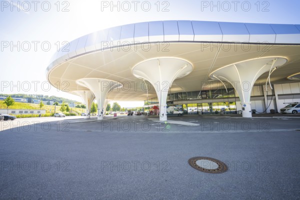 Modern, futuristic building with a curved roof in a sunny neighbourhood, Munich, Germany