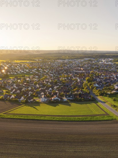 Aerial view of a village surrounded by fields at sunset with rural charm, Althengstett, district of Calw, Germany