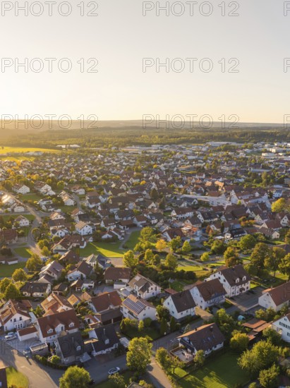 Aerial view of a village at sunset with many houses, trees and rural atmosphere, Althengstett, district of Calw, Germany