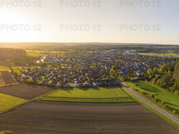 Aerial view of a village and its surroundings with fields and rural landscape at sunset, Althengstett, district of Calw, Germany
