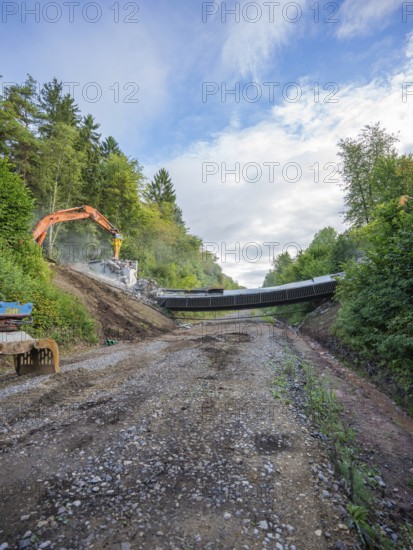 A wide path leads to a demolition site, excavator and fragments visible, bridge demolition, Calw, Germany