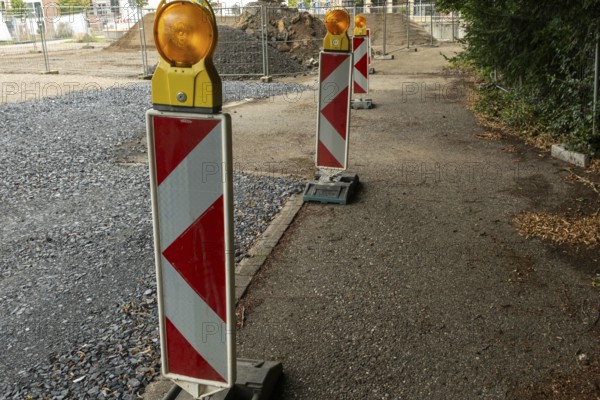 Borken, NRW, Germany, Red and white striped warning posts with flashing orange lights marking a closed road during construction