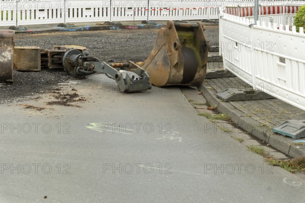 Borken, NRW, Germany, Excavator bucket and other equipment left on the ground at urban construction site