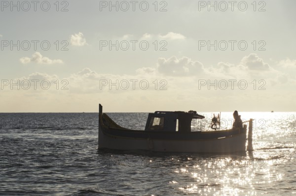 Silhouette of Maltese boat on Mediterranean Sea by Marsaxlokk, south of Malta