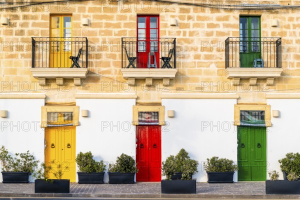 Limestone building with colorful doors in Marsaxlokk, fisherman village on Malta