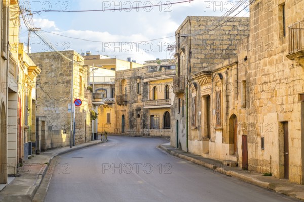 Charming street between limestone building in Nadur, Gozo island, Malta