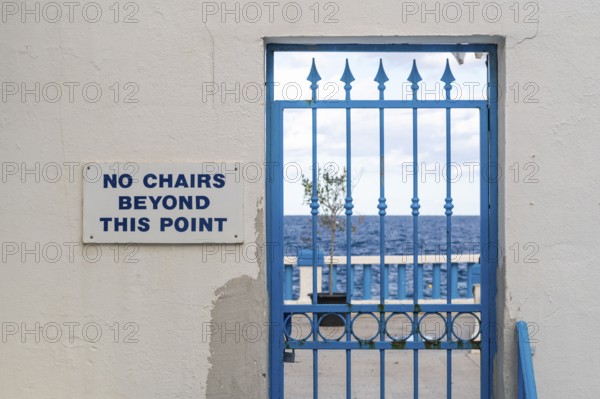 Blue locked door with sign No chairs beyond this point, Malta