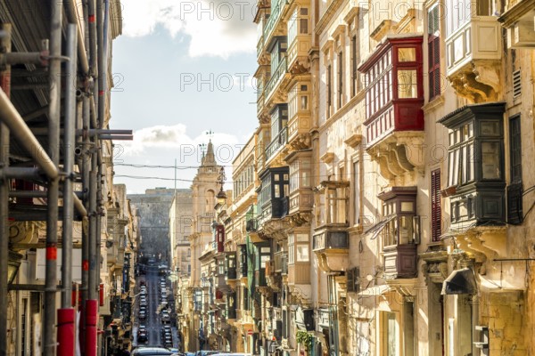 Street with amazing historic houses with colorful wooden balconies in La Valletta, capital city of Malta