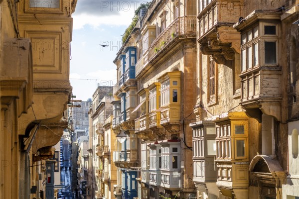 Street with amazing historic houses with colorful wooden balconies in La Valletta, capital city of Malta