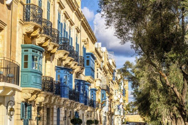 Street with amazing historic houses with colorful wooden balconies in La Valletta, capital city of Malta