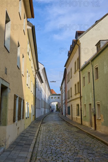 Narrow alley with cobblestones lined with colourful houses under a clear sky, Waffnergasse, Regensburg, Bavaria, Germany