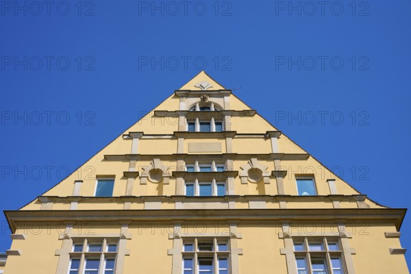Building with striking triangular gable and windows against a clear sky, Regensburg, Bavaria, Germany