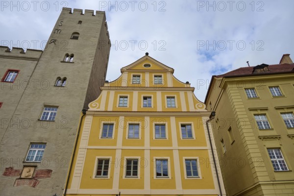 Yellow and sand-coloured building with striking tower and blue sky in Regensburg, Regensburg, Bavaria, Germany