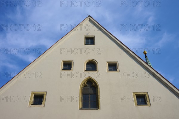 Gable of an old building with Gothic windows in front of a blue sky, Regensburg, Bavaria, Germany