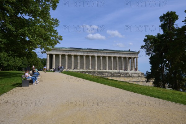 Building with columns in a green setting with walkers and trees, Walhalla, Donaustauf, Regensburg, Bavaria, Germany