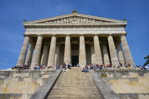 Temple-like structure with monumental columns and visitors on a staircase under a blue sky, Walhalla, Donaustauf, Regensburg, Bavaria, Germany