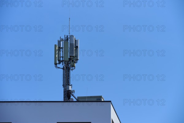 Communication tower on the roof of a building under a clear blue sky, Regensburg, Bavaria, Germany