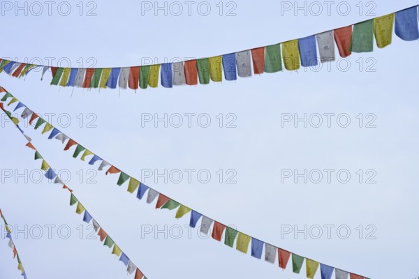 Colourful prayer flags flutter in the blue sky, conveying a feeling of freedom and peace, Bavaria, Germany
