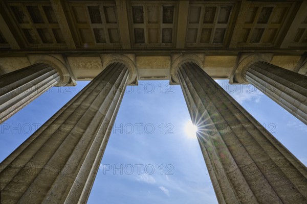 Classical stone pillars rise into the sky, pierced by rays of sunlight, Walhalla, Donaustauf, Regensburg, Bavaria, Germany