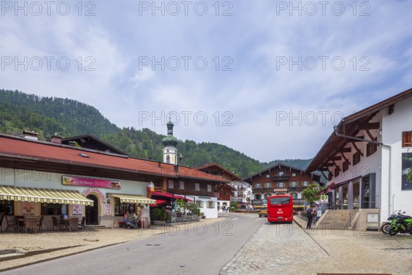 Village scene with houses, shops, bus, town hall and parish church St. Pankratius, Reit im Winkl, Chiemgau, Upper Bavaria, Bavaria, Germany