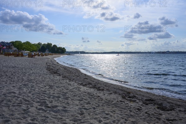 Quiet, sun-drenched beach with reflecting water and blue sky with white clouds, Heikendorf, Plön district, Kiel Fjord, Schleswig-Holstein, Germany