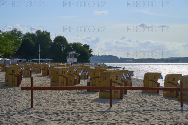 Beach chairs on a quiet beach with blue sky and water in the background under the summer sun, Heikendorf, Kreis Plön, Kieler Förde, Schleswig-Holstein, Germany