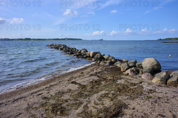 Stone breakwater in the sea on a sunny beach day with blue sky, Heikendorf, Plön district, Kiel Fjord, Schleswig-Holstein, Germany