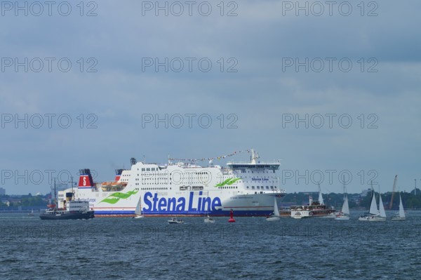 Stena Line ferry on the sea with sailing boats in the surroundings and a cloudy sky, Windjammer Parade Kiel 2025, Heikendorf, Kreis Plön, Kieler Förde, Schleswig-Holstein, Germany