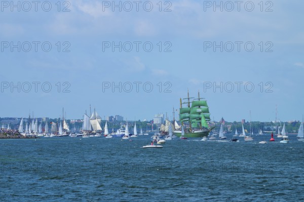 Green tall ship Alexander von Humbold 2 surrounded by many boats in front of an urban backdrop, Windjammer Parade Kiel 2025, Heikendorf, Plön district, Kiel Fjord, Schleswig-Holstein, Germany