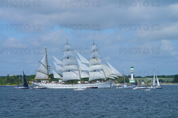 White sailing ship Gorch Fock on the sea with several big sails under blue sky, Windjammer Parade Kiel 2025, lighthouse Friedrichsort, district Plön, Kieler Förde, Schleswig-Holstein, Germany