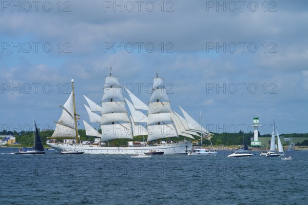 Large sailing ship Gorch Fock with white sails on the sea under a blue sky near a harbour, Windjammer Parade Kiel 2025, lighthouse Friedrichsort, district Plön, Kieler Förde, Schleswig-Holstein, Germany