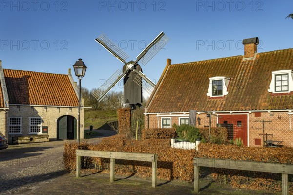 Traditional houses and windmill of the inhabited former fortress of Bourtange, Groningen, Netherlands
