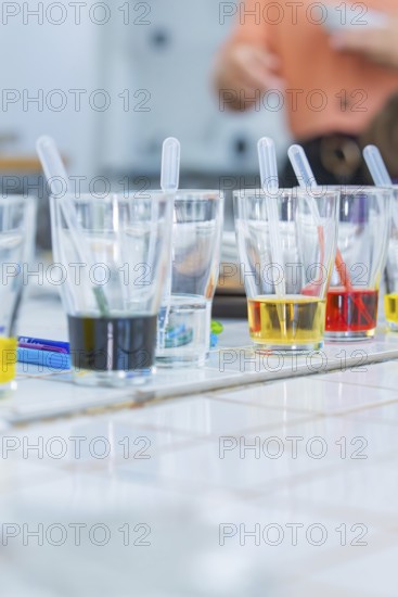 Several glasses on a table filled with colourful liquids and pipettes ready for an experiment, Youth Research Centre