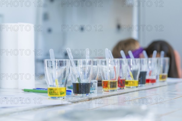 Glasses with different coloured liquids and pipettes arranged for a laboratory experiment, Youth Research Centre