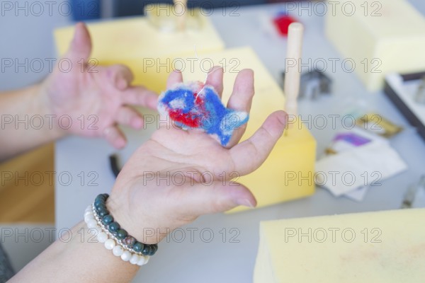 Person holding a colourful piece of foam while crafting with different materials, Youth Research Centre