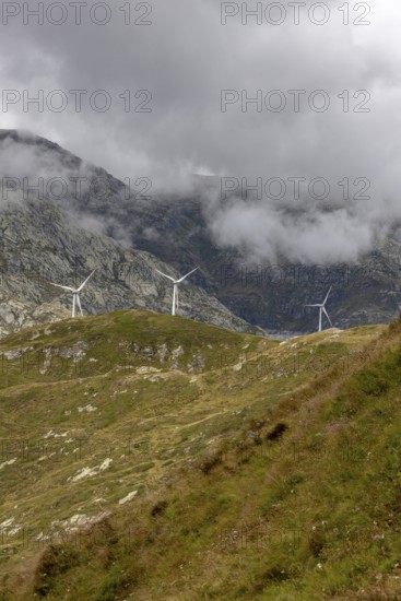 Wind turbines on the Gotthard Pass in the clouds, view from Passo Scimfuss, Airolo, Ticino, Switzerland