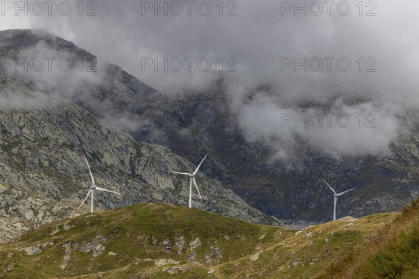 Wind turbines on the Gotthard Pass in the clouds, view from Passo Scimfuss, Airolo, Ticino, Switzerland