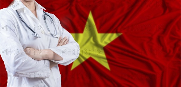 Doctor with crossed arms on Vietnam flag. Vietnam health and care concept. Female doctor on Vietnam flag