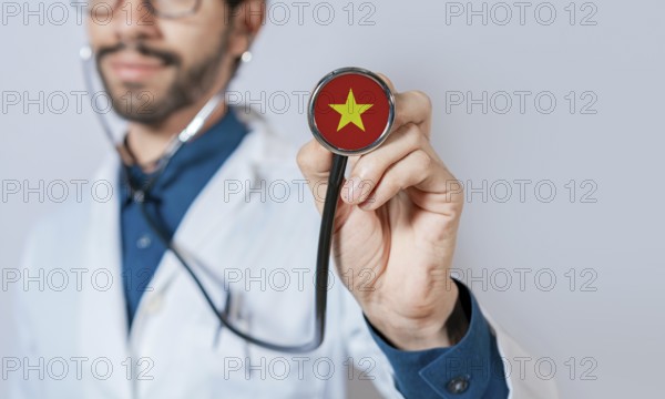 Doctor holding stethoscope with Vietnam flag. Vietnam health and care concept, Vietnam flag on stethoscope