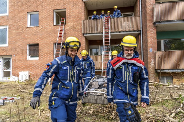 Rescue and recovery of people after a drone attack on residential buildings in a civil defence scenario, in which access is partly possible via wall breakthroughs or upper floors, here with a ladder slide, FÜLEX25, of the THW, Technisches Hilfswerk, Landesverband North Rhine-Westphalia, on 4 weekends over 3500 volunteers from the 127 North Rhine-Westphalia local associations practice many different deployment scenarios from the field of disaster control and civil defence