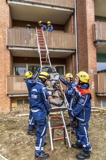 Rescue and recovery of people after a drone attack on residential buildings in a civil defence scenario, in which access is partly possible via wall breakthroughs or upper floors, here with a ladder slide, FÜLEX25, of the THW, Technisches Hilfswerk, Landesverband North Rhine-Westphalia, on 4 weekends over 3500 volunteers from the 127 North Rhine-Westphalia local associations practice many different deployment scenarios from the field of disaster control and civil defence