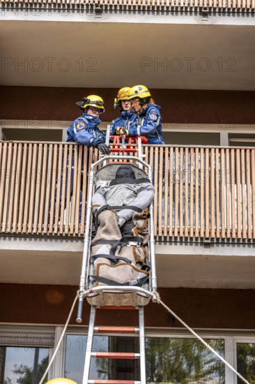 Rescue and recovery of people after a drone attack on residential buildings in a civil defence scenario, in which access is partly possible via wall breakthroughs or upper floors, here with a ladder slide, FÜLEX25, of the THW, Technisches Hilfswerk, Landesverband North Rhine-Westphalia, on 4 weekends over 3500 volunteers from the 127 North Rhine-Westphalia local associations practice many different deployment scenarios from the field of disaster control and civil defence