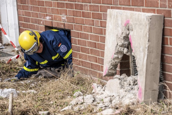 Rescue and recovery of people after a drone attack on residential buildings in a civil defence scenario, in which access is partly possible via wall breakthroughs or upper floors, simulated wall breakthrough with a concrete slab, FÜLEX25, of the THW, Technisches Hilfswerk, Landesverband North Rhine-Westphalia, on 4 weekends over 3500 volunteers from the 127 North Rhine-Westphalia local associations, many different deployment scenarios, from the field of disaster control and civil defence