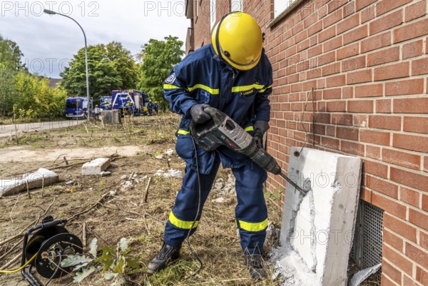 Rescue and recovery of people after a drone attack on residential buildings in a civil defence scenario, in which access is partly possible via wall breakthroughs or upper floors, simulated wall breakthrough with a concrete slab, FÜLEX25, of the THW, Technisches Hilfswerk, Landesverband North Rhine-Westphalia, on 4 weekends over 3500 volunteers from the 127 North Rhine-Westphalia local associations, many different deployment scenarios, from the field of disaster control and civil defence