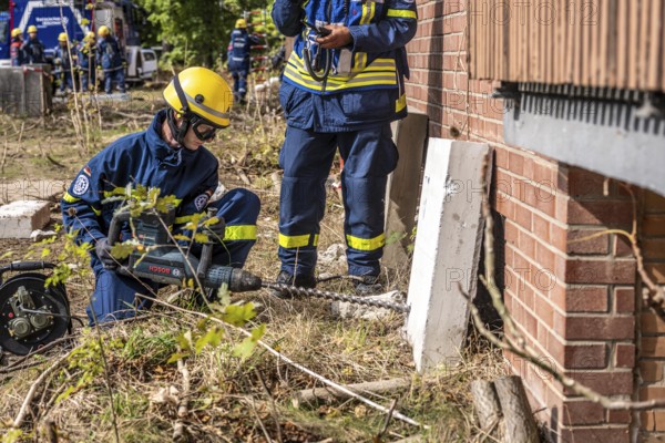 Rescue and recovery of people after a drone attack on residential buildings in a civil defence scenario, in which access is partly possible via wall breakthroughs or upper floors, simulated wall breakthrough with a concrete slab, FÜLEX25, of the THW, Technisches Hilfswerk, Landesverband North Rhine-Westphalia, on 4 weekends over 3500 volunteers from the 127 North Rhine-Westphalia local associations, many different deployment scenarios, from the field of disaster control and civil defence