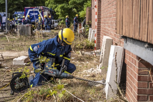Rescue and recovery of people after a drone attack on residential buildings in a civil defence scenario, in which access is partly possible via wall breakthroughs or upper floors, simulated wall breakthrough with a concrete slab, FÜLEX25, of the THW, Technisches Hilfswerk, Landesverband North Rhine-Westphalia, on 4 weekends over 3500 volunteers from the 127 North Rhine-Westphalia local associations, many different deployment scenarios, from the field of disaster control and civil defence