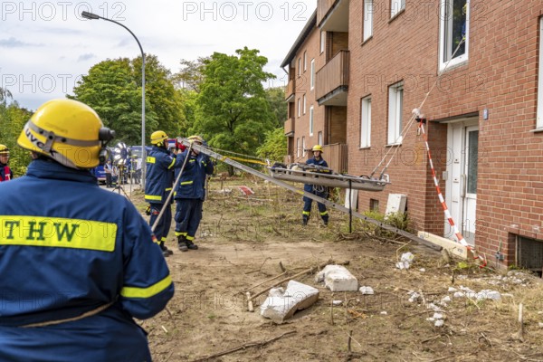 Rescue and recovery of people after a drone attack on residential buildings in a civil defence scenario, in which access is partly possible via wall breakthroughs or upper floors, here with a so-called ladder lever, FÜLEX25, of the THW, Technisches Hilfswerk, Landesverband North Rhine-Westphalia, on 4 weekends over 3500 volunteers from the 127 North Rhine-Westphalia local associations practice many different deployment scenarios from the field of disaster control and civil defence
