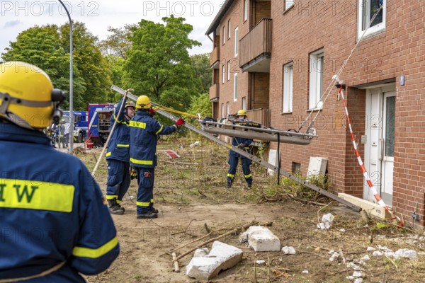 Rescue and recovery of people after a drone attack on residential buildings in a civil defence scenario, in which access is partly possible via wall breakthroughs or upper floors, here with a so-called ladder lever, FÜLEX25, of the THW, Technisches Hilfswerk, Landesverband North Rhine-Westphalia, on 4 weekends over 3500 volunteers from the 127 North Rhine-Westphalia local associations practice many different deployment scenarios from the field of disaster control and civil defence