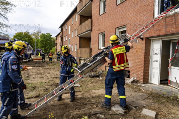 Rescue and recovery of people after a drone attack on residential buildings in a civil defence scenario, in which access is partly possible via wall breakthroughs or upper floors, here with a ladder slide, FÜLEX25, of the THW, Technisches Hilfswerk, Landesverband North Rhine-Westphalia, on 4 weekends over 3500 volunteers from the 127 North Rhine-Westphalia local associations practice many different deployment scenarios from the field of disaster control and civil defence